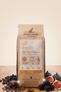 Bag of 'off leash' coffee from Rescue Coffee with figs, blackberries, and chocolate on a wooden surface.