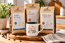 Three bags of Rescue Coffee dog coffee in different flavors (wake & wag, go fetch!, black dog espresso) arranged on a wooden board with a white ceramic mug that says ' Sip a cup Save a pup' and scattered coffee beans.